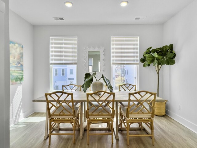 dining area featuring breakfast area, visible vents, light wood-style flooring, and baseboards