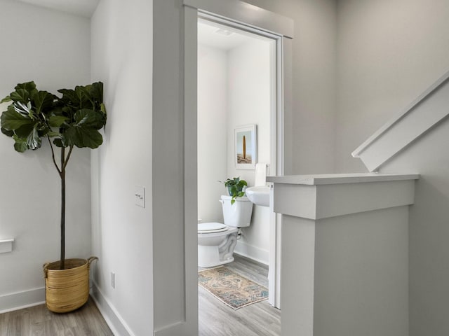 bathroom featuring baseboards, toilet, and wood finished floors