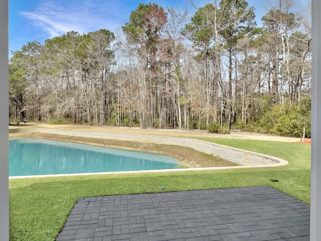 view of pool featuring a lawn