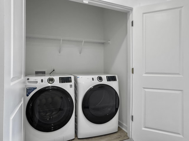 washroom with laundry area, independent washer and dryer, and wood finished floors