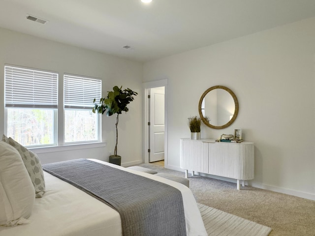 bedroom featuring carpet floors, visible vents, and baseboards