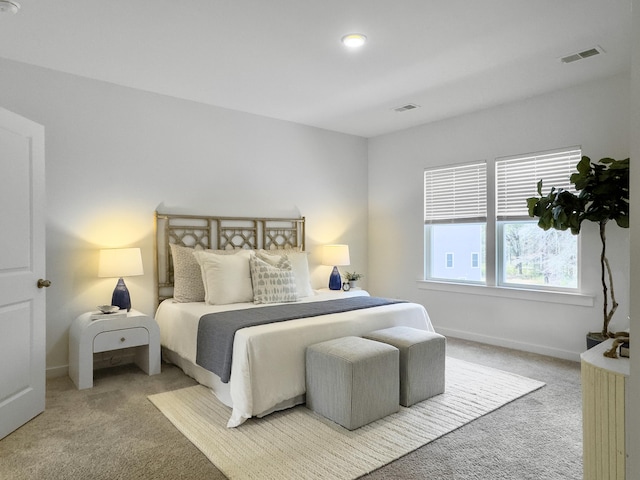 bedroom featuring light colored carpet, visible vents, and baseboards