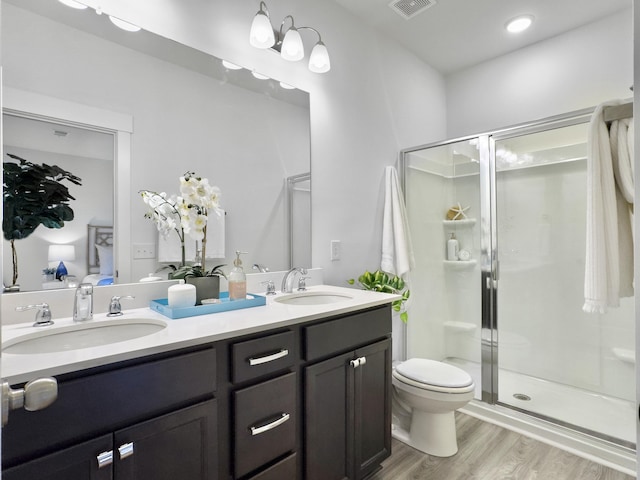 full bath featuring wood finished floors, a stall shower, and a sink