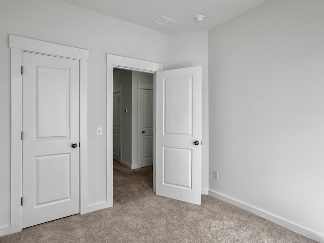 unfurnished bedroom featuring carpet floors, visible vents, and baseboards