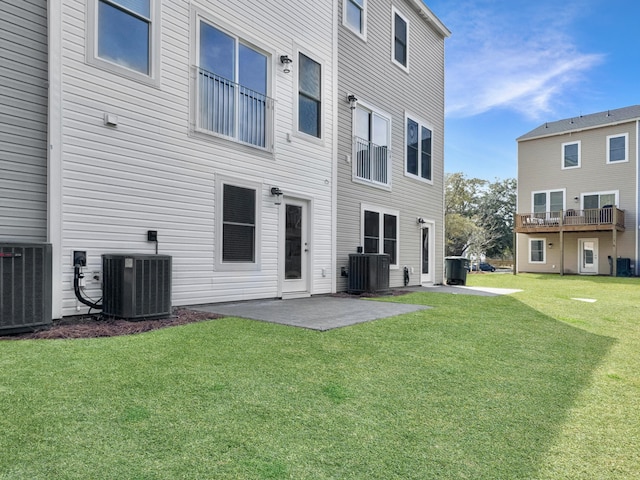 back of house with central AC unit, a patio, and a yard