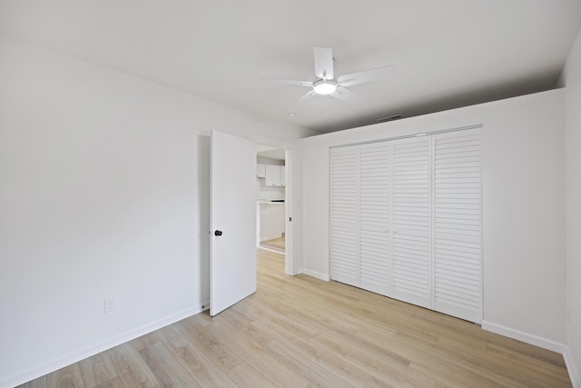 unfurnished bedroom featuring light hardwood / wood-style floors, a closet, and ceiling fan