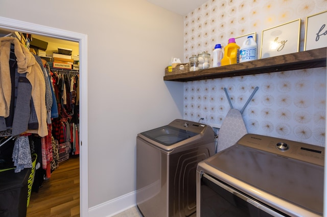 clothes washing area with wood-type flooring and separate washer and dryer