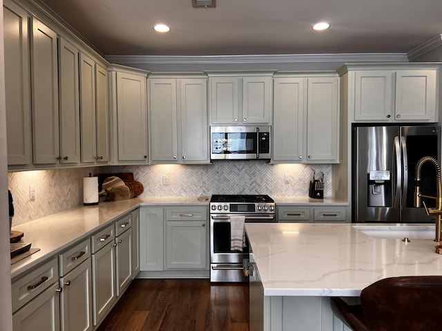 kitchen featuring a breakfast bar, stainless steel appliances, dark hardwood / wood-style floors, tasteful backsplash, and light stone countertops