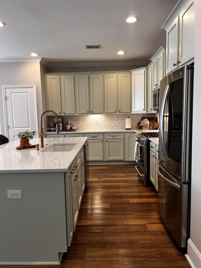 kitchen featuring dark wood-type flooring, sink, a center island with sink, appliances with stainless steel finishes, and light stone countertops