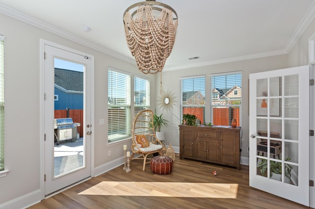 living area featuring an inviting chandelier, ornamental molding, and wood-type flooring