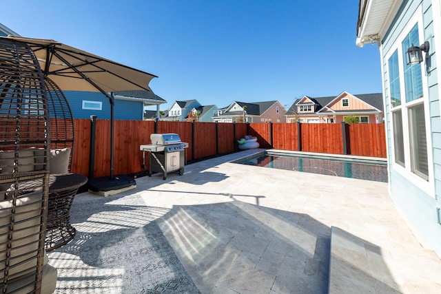 view of patio / terrace with a fenced in pool and area for grilling