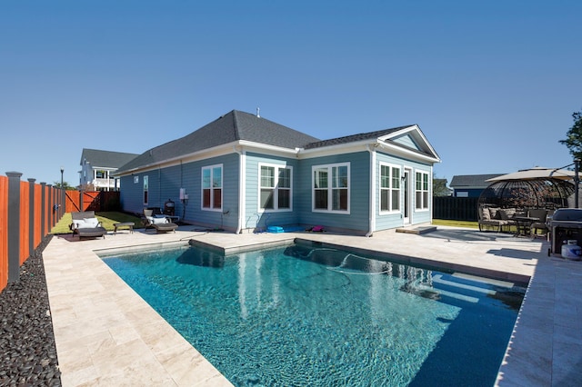 back of property featuring a fenced in pool and a patio area