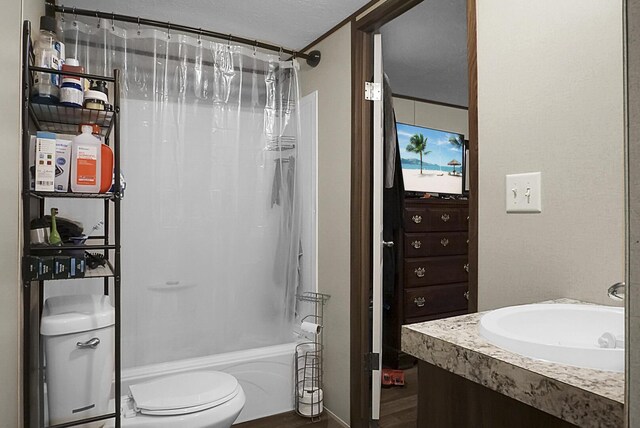 full bathroom with toilet, crown molding, vanity, shower / bath combo, and a textured ceiling