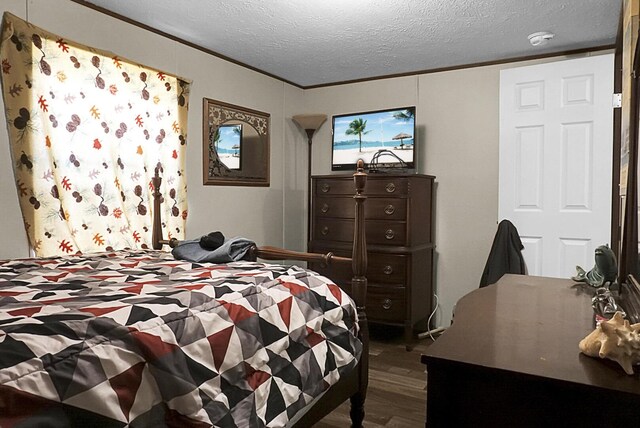 bedroom with dark hardwood / wood-style floors and a textured ceiling