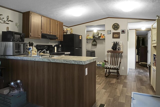 kitchen with black appliances, a textured ceiling, lofted ceiling, and hardwood / wood-style floors