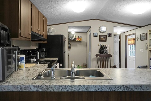 kitchen with a textured ceiling, sink, range, and lofted ceiling