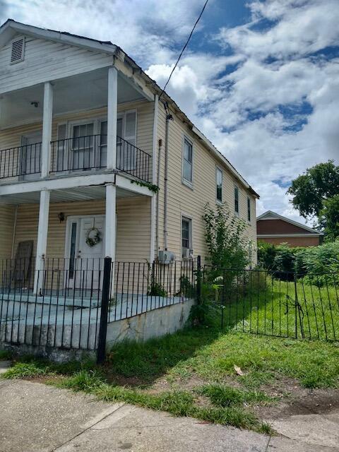 view of property exterior featuring a balcony and covered porch