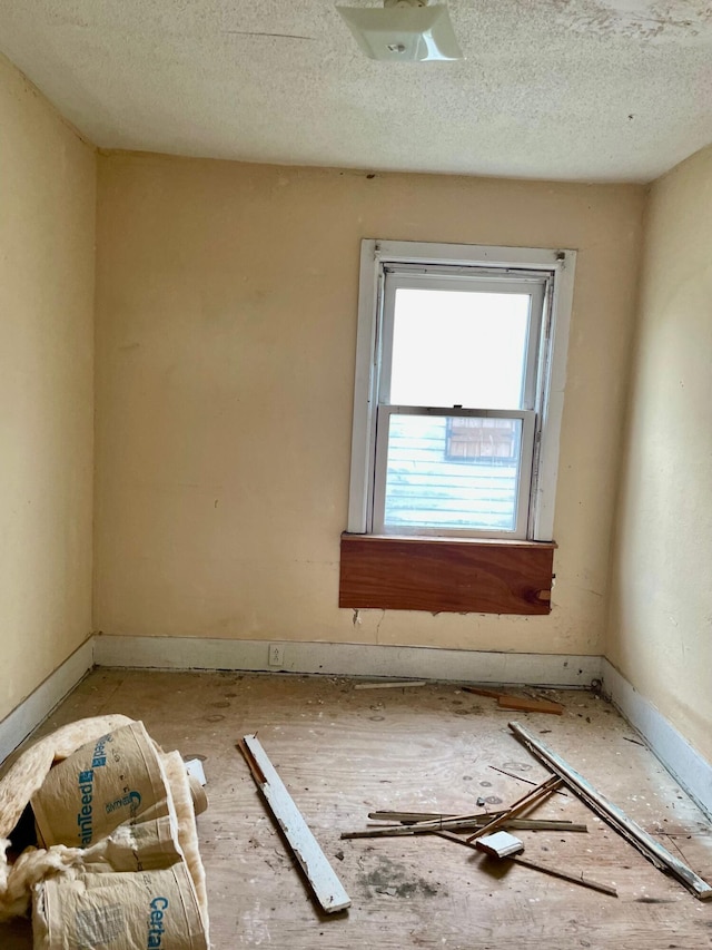 unfurnished room with a textured ceiling