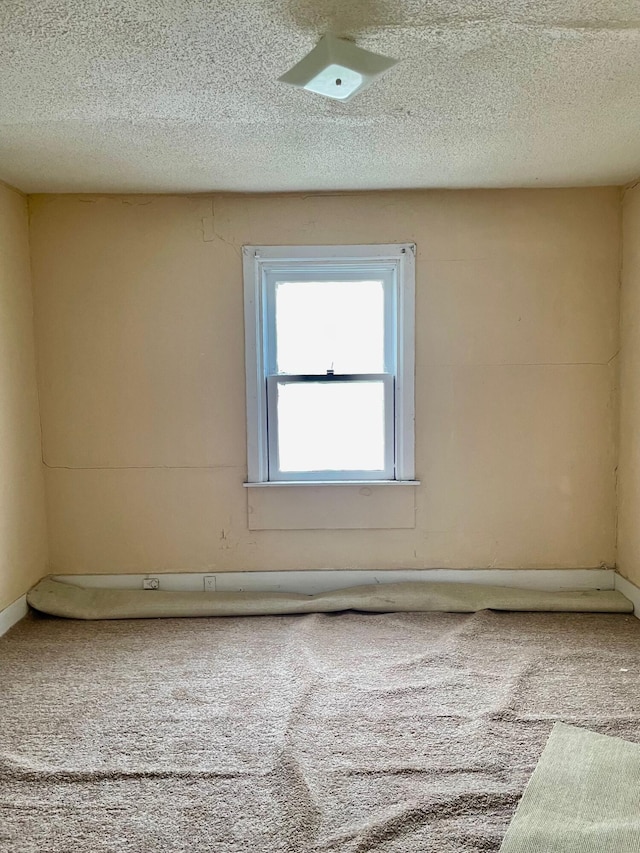 unfurnished room featuring carpet floors and a textured ceiling