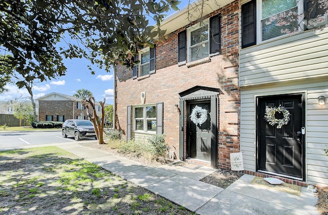 view of exterior entry with brick siding