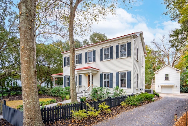 colonial house with driveway and a fenced front yard