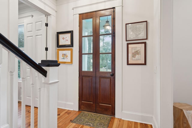 entryway with wood finished floors, stairs, and baseboards