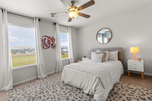 bedroom featuring multiple windows, light carpet, and ceiling fan