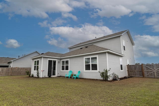 rear view of house featuring a lawn