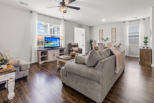 living room with ceiling fan and dark wood-type flooring