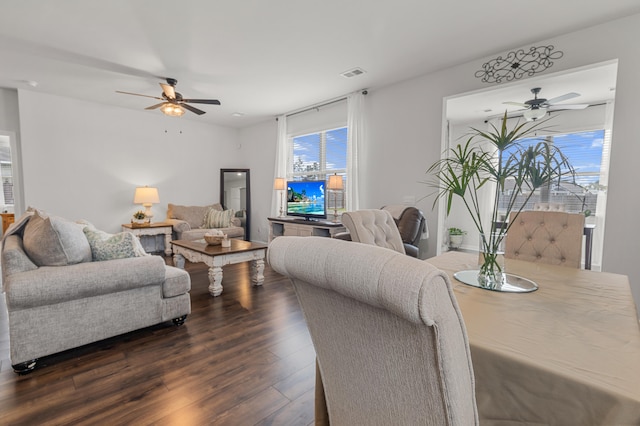 living room featuring ceiling fan and dark hardwood / wood-style floors