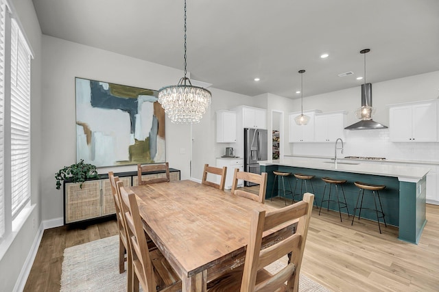 dining room featuring light wood-style floors, recessed lighting, baseboards, and a chandelier