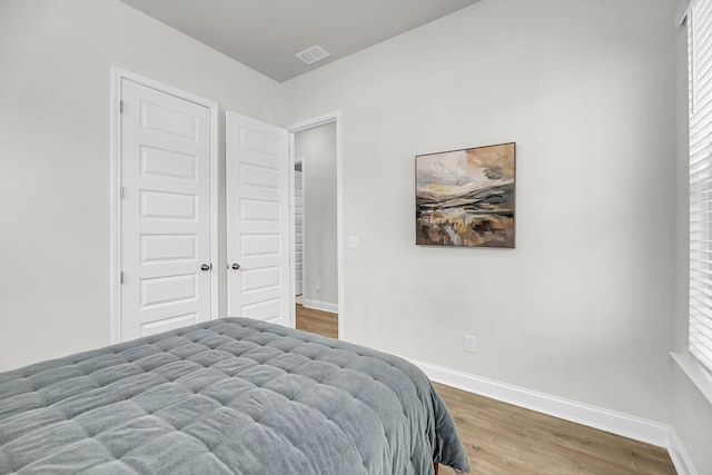 bedroom with wood finished floors and baseboards