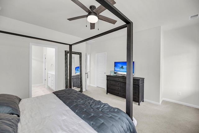 bedroom featuring light colored carpet, baseboards, and ensuite bath