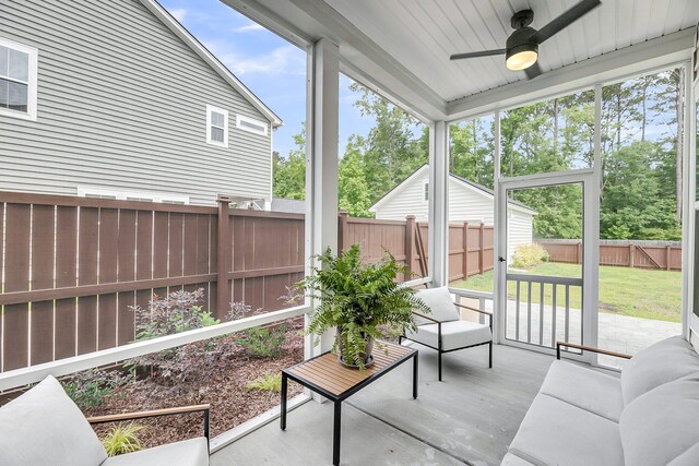 sunroom / solarium with a ceiling fan, healthy amount of natural light, and an outdoor living space