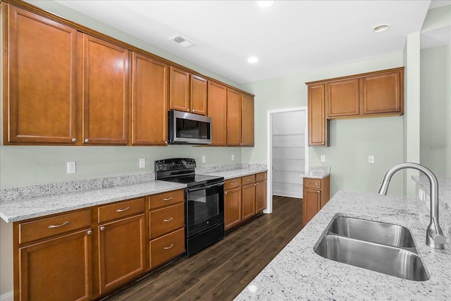 kitchen with electric range, sink, light stone counters, and dark hardwood / wood-style floors