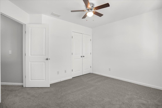 unfurnished bedroom with ceiling fan, a closet, and dark colored carpet