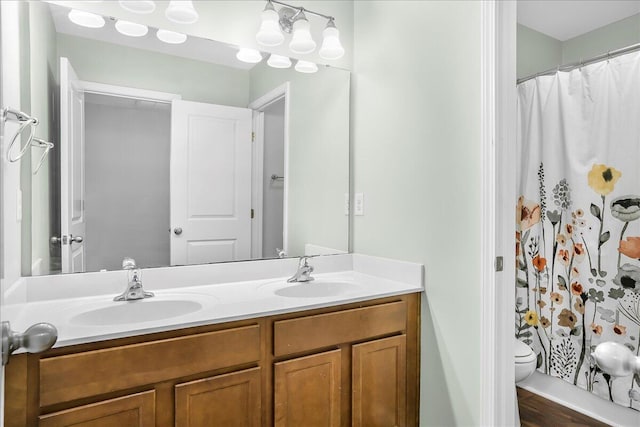 bathroom featuring walk in shower, hardwood / wood-style floors, vanity, and toilet