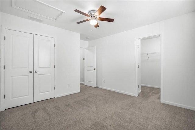 unfurnished bedroom featuring ceiling fan, light colored carpet, and a spacious closet