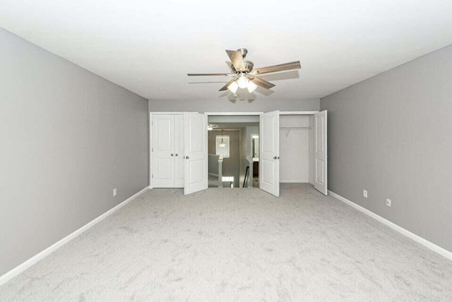 unfurnished bedroom featuring ceiling fan and light carpet