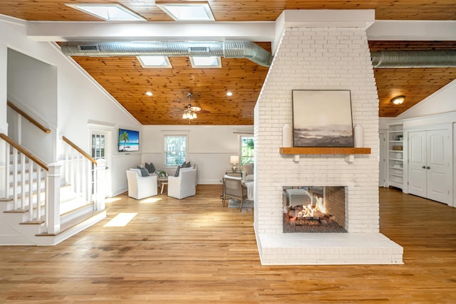 3002 Waterway Blvd, Isle Of Palms, SC 29451 - living room featuring a skylight, a fireplace, wooden ceiling, stairway, and wood finished floors