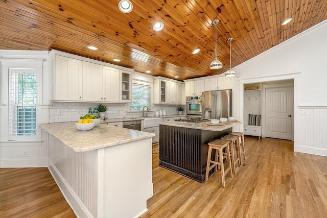 3002 Waterway Blvd, Isle Of Palms, SC 29451 - kitchen with appliances with stainless steel finishes, wood ceiling, a kitchen bar, glass insert cabinets, and a peninsula