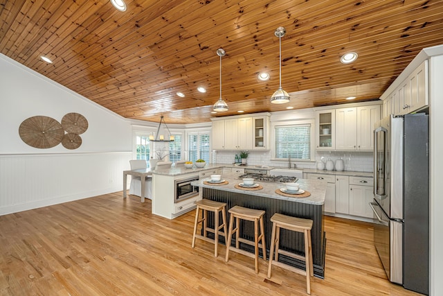 3002 Waterway Blvd, Isle Of Palms, SC 29451 - kitchen featuring appliances with stainless steel finishes, wood ceiling, a kitchen breakfast bar, a peninsula, and wainscoting