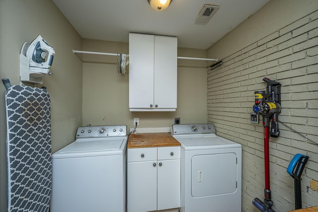 3002 Waterway Blvd, Isle Of Palms, SC 29451 - washroom featuring cabinet space, washer and dryer, and brick wall