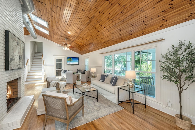 3002 Waterway Blvd, Isle Of Palms, SC 29451 - living area featuring a fireplace, vaulted ceiling, wood finished floors, a ceiling fan, and stairway