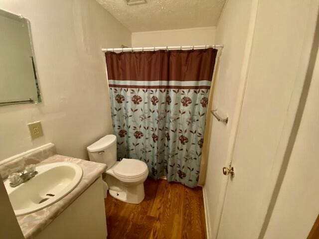 1806 S Charleston Ave, Fairfax, SC 29827 - full bathroom with vanity, toilet, a shower with shower curtain, a textured ceiling, and wood finished floors
