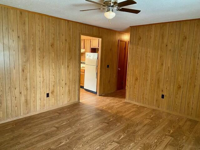 1806 S Charleston Ave, Fairfax, SC 29827 - empty room featuring wood walls, light wood finished floors, and ceiling fan