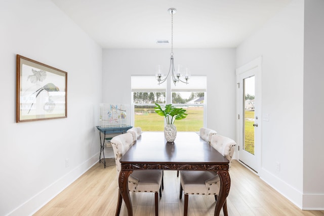 dining space featuring light hardwood / wood-style flooring and a chandelier