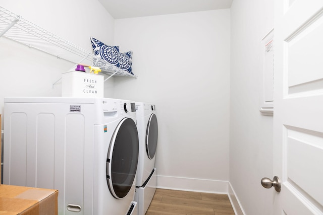 clothes washing area with light wood-type flooring and washer and clothes dryer