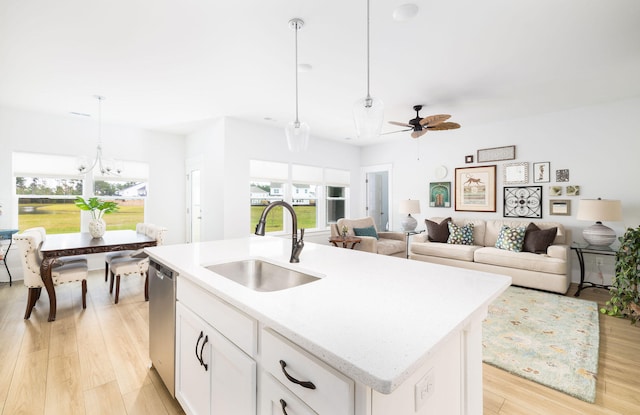 kitchen featuring a wealth of natural light, white cabinetry, a kitchen island with sink, and sink