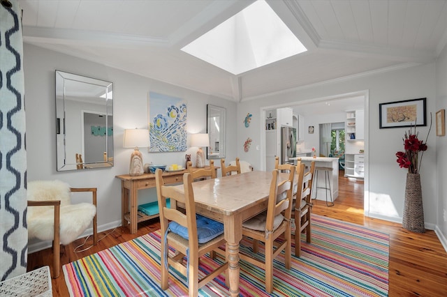 dining space featuring light hardwood / wood-style floors, lofted ceiling with skylight, and wood ceiling